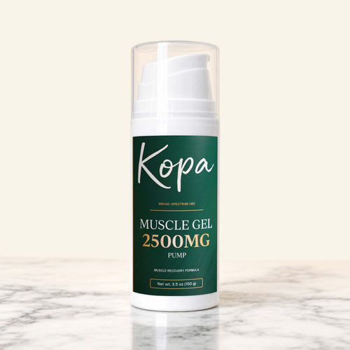 Kopa Muscle Gel 2500mg CBD in a white pump bottle with a dark green label, standing on marble