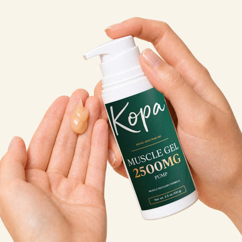 Hands holding the Kopa Muscle Gel 2500mg pump bottle with a dose of gel in one palm