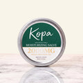 Kopa Moisturizing Salve 2000mg CBD in a closed round metal tin with a dark green label